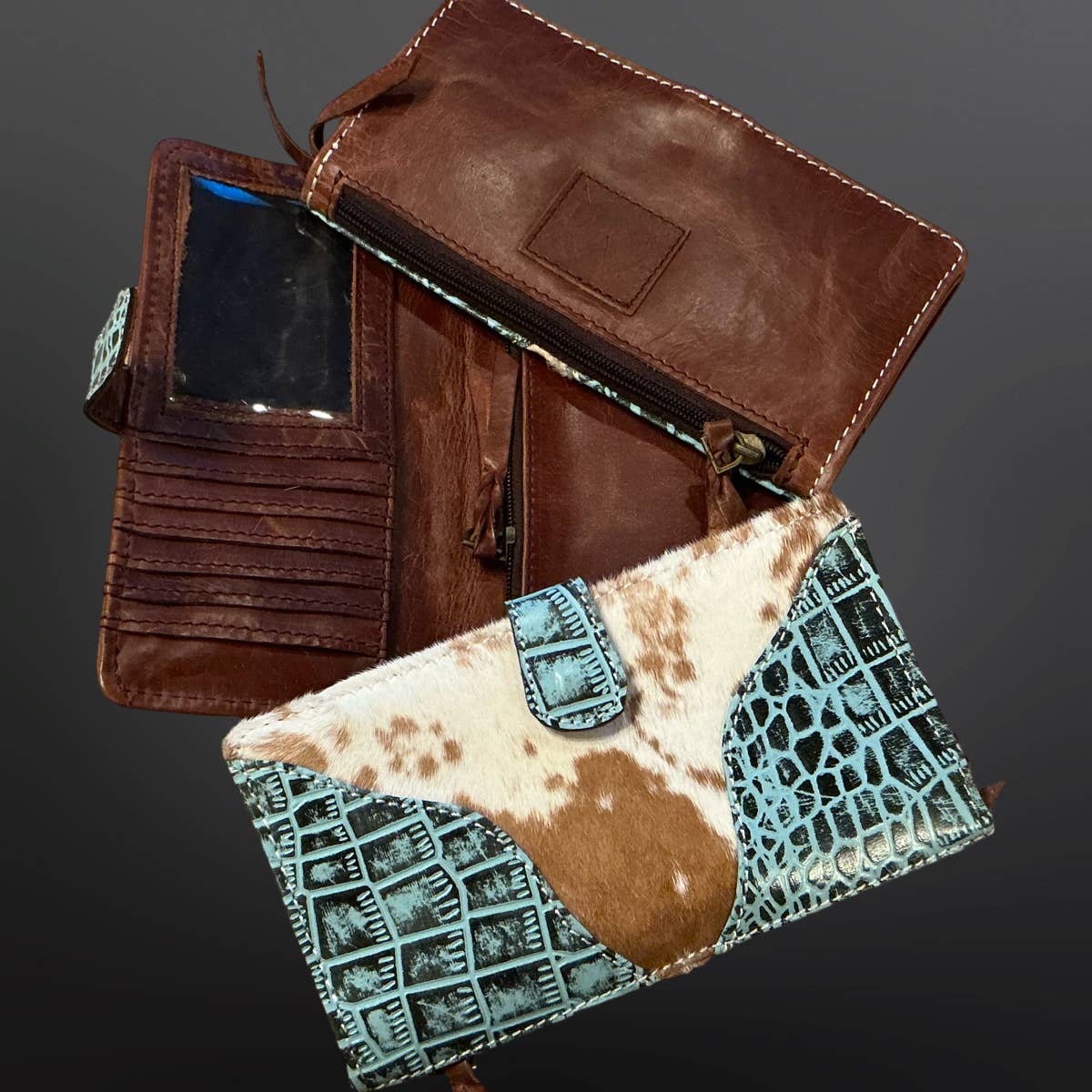 Brown leather clutch with cowhide pattern on a dark background