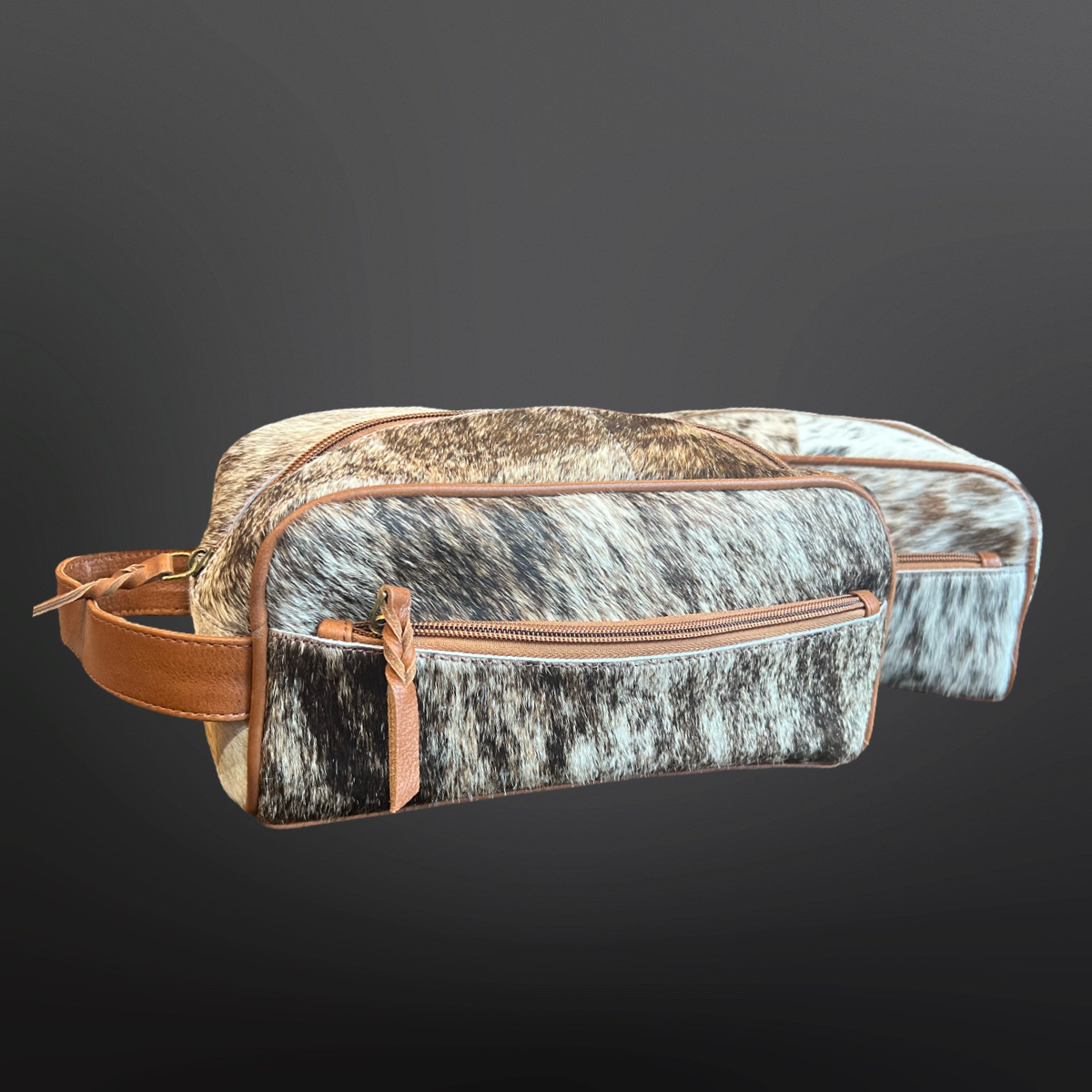 Cowhide leather bag with brown leather straps on a dark background