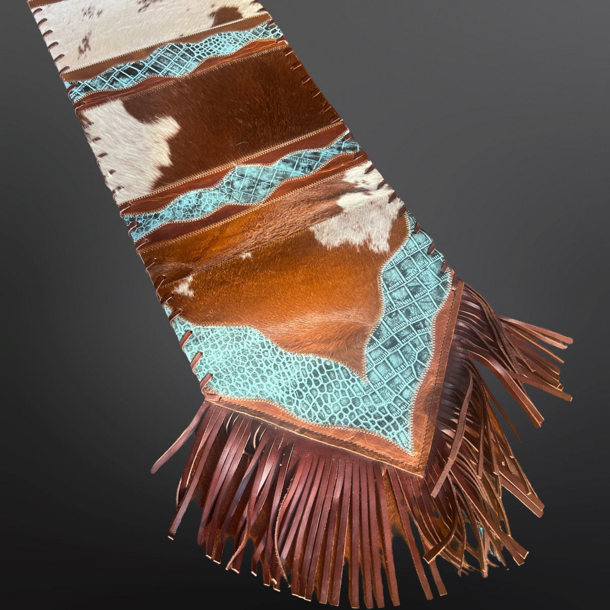 Cowhide table runner with fringe On dark background 