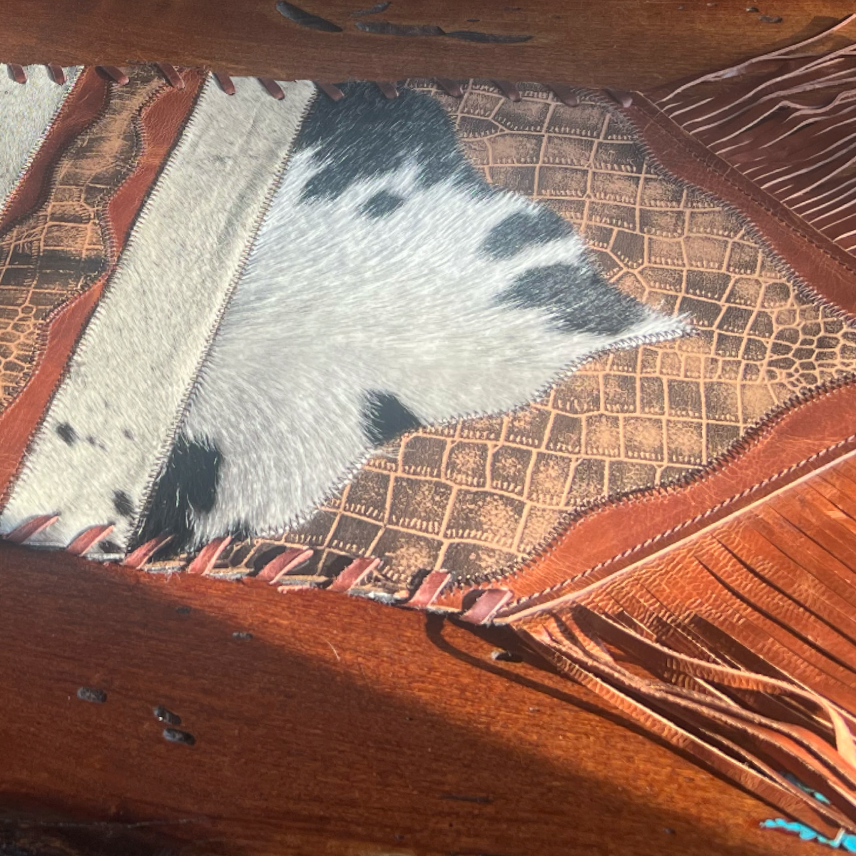Cowhide table runner with fringe On wood background