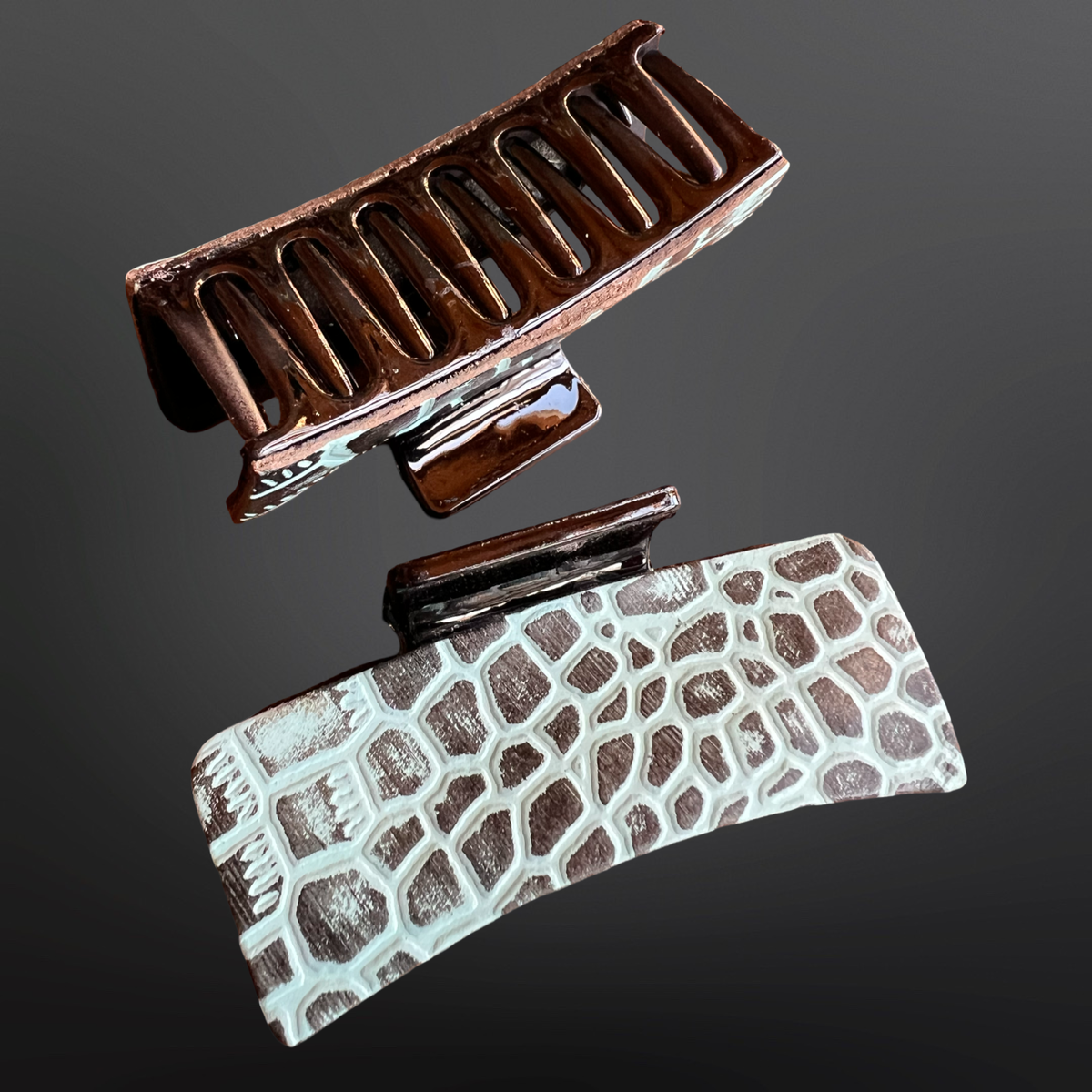 Two hair clips with a textured pattern on a dark background
