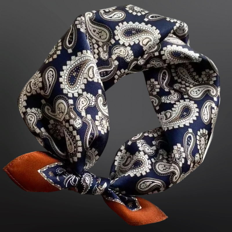 Navy blue and white paisley patterned headband with brown fabric ends on a dark background