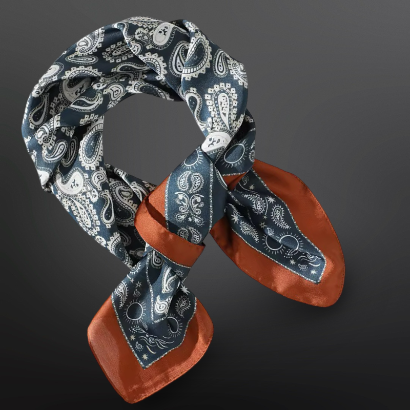 Blue paisley patterned scarf with rust-colored ends on a dark background