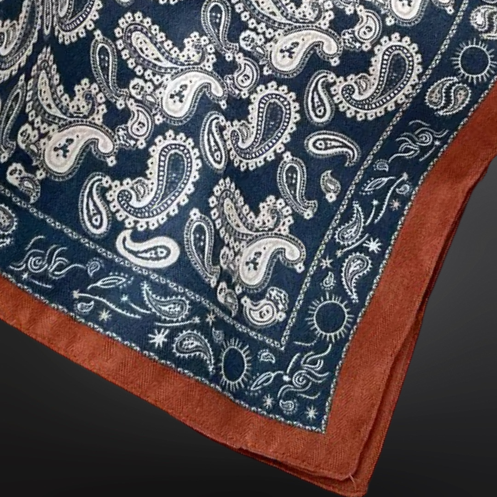 Blue scarf with white paisley pattern on a dark background