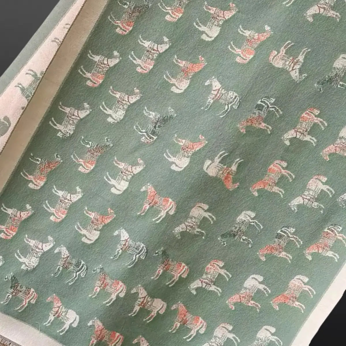 Scarf with a pattern of horses on a green background