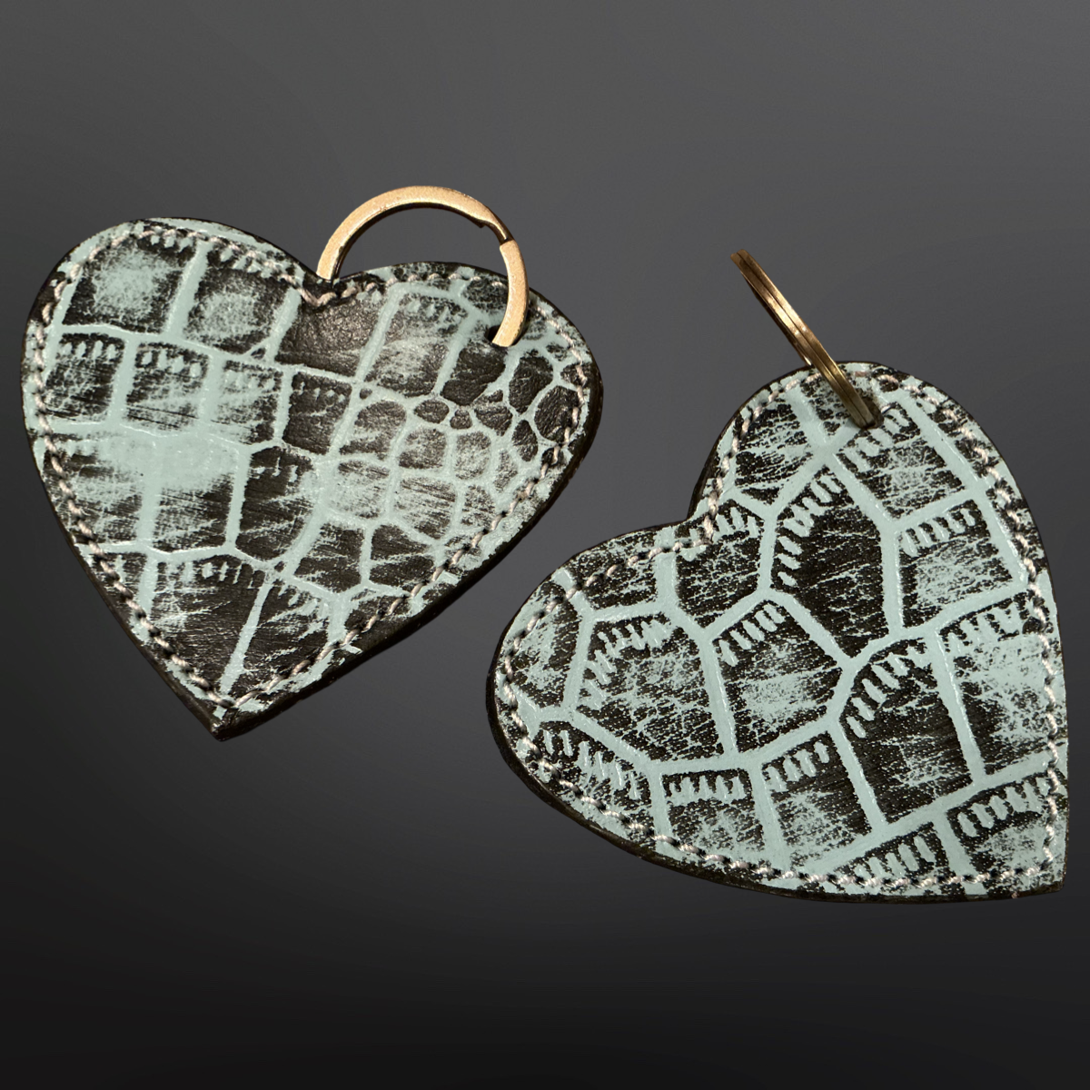 Heart-shaped keychains with textured pattern on a dark background
