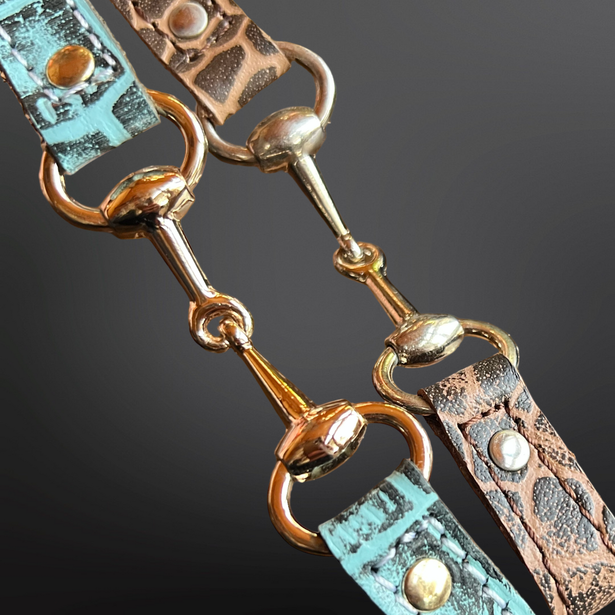 Close-up of a decorative hatband with turquoise and brown leather straps and gold hardware on a dark background.