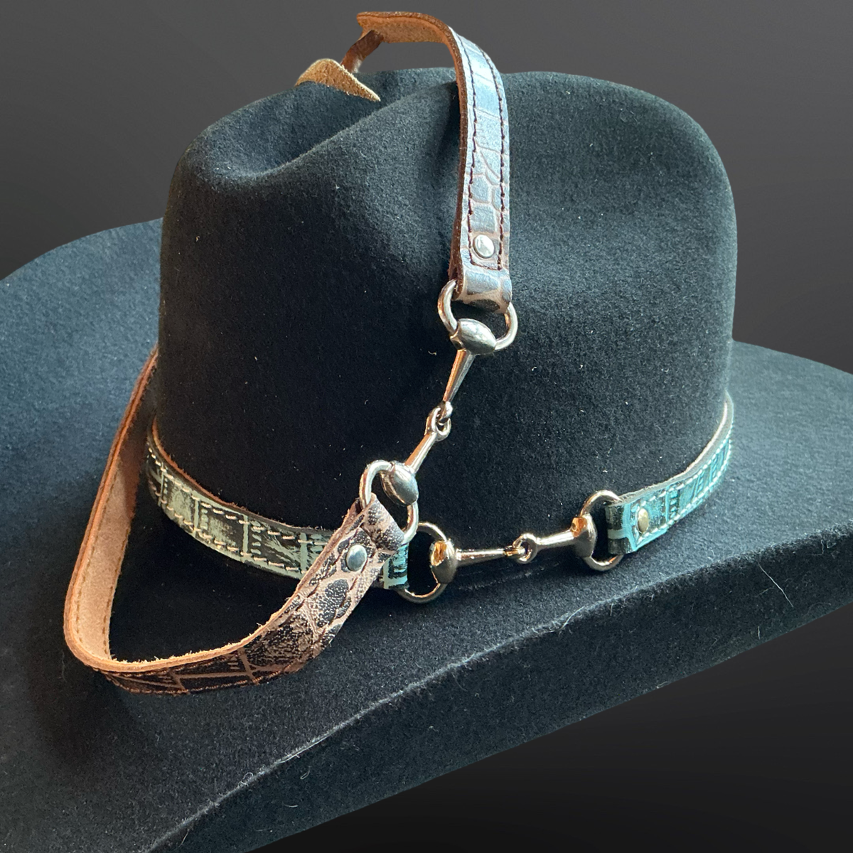 Black cowboy hat with a leather hat band on a dark background