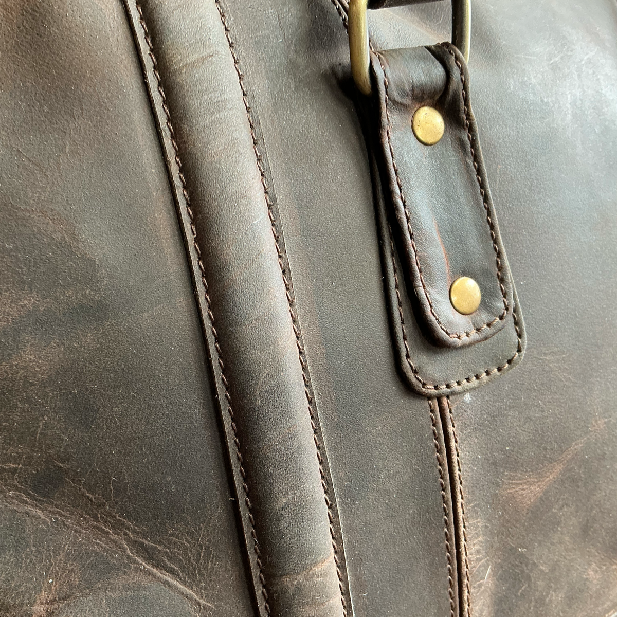 Close-up of a brown leather bag with stitching details