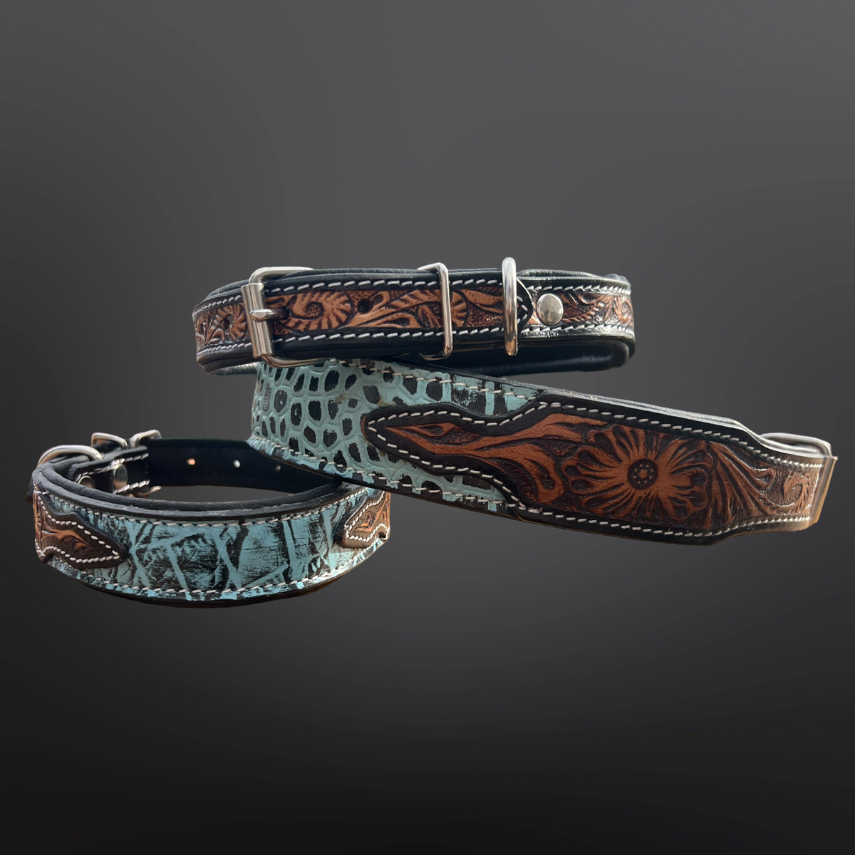 Three dog collars with intricate tooled leather designs on a dark background
