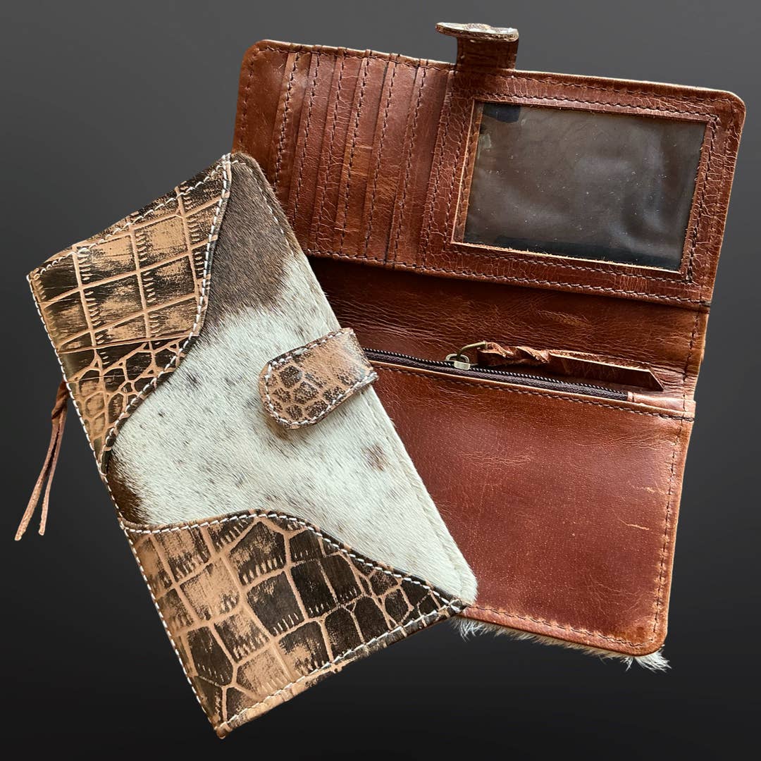 Brown leather wallet with cowhide accents on a dark gray background
