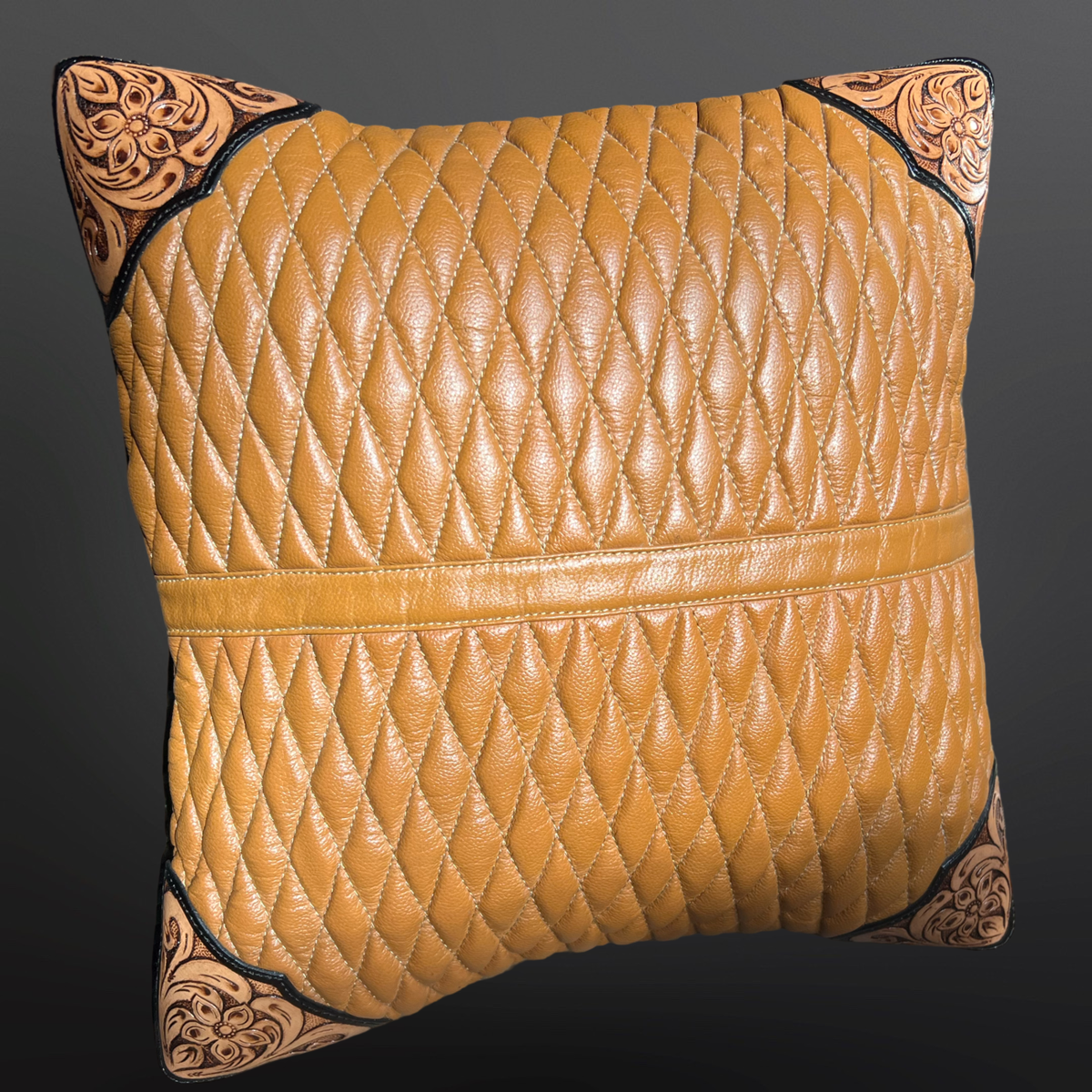 Quilted brown pillow with tooled leather corners on a dark background