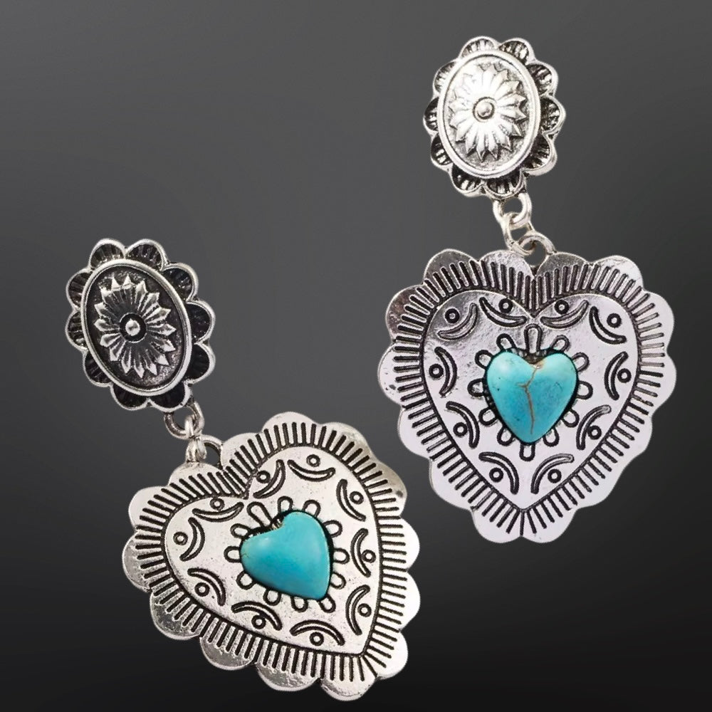 Silver earrings with turquoise heart stones on a dark background