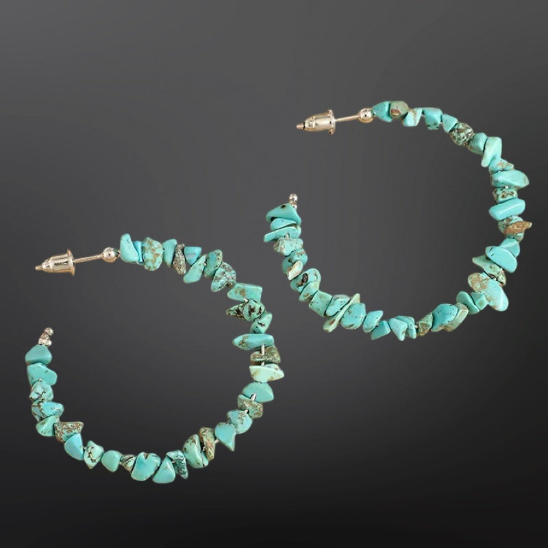 Turquoise hoop earrings on a dark background