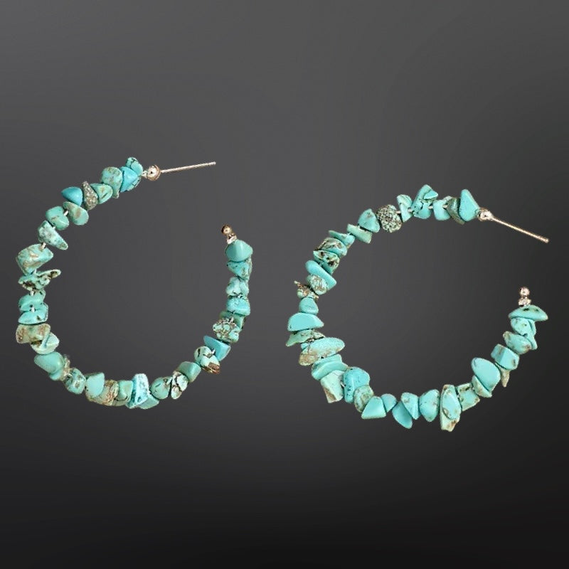 Turquoise hoop earrings on a dark background