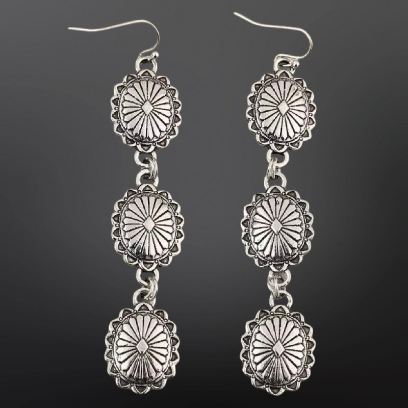 Pair of silver dangle earrings on a black background
