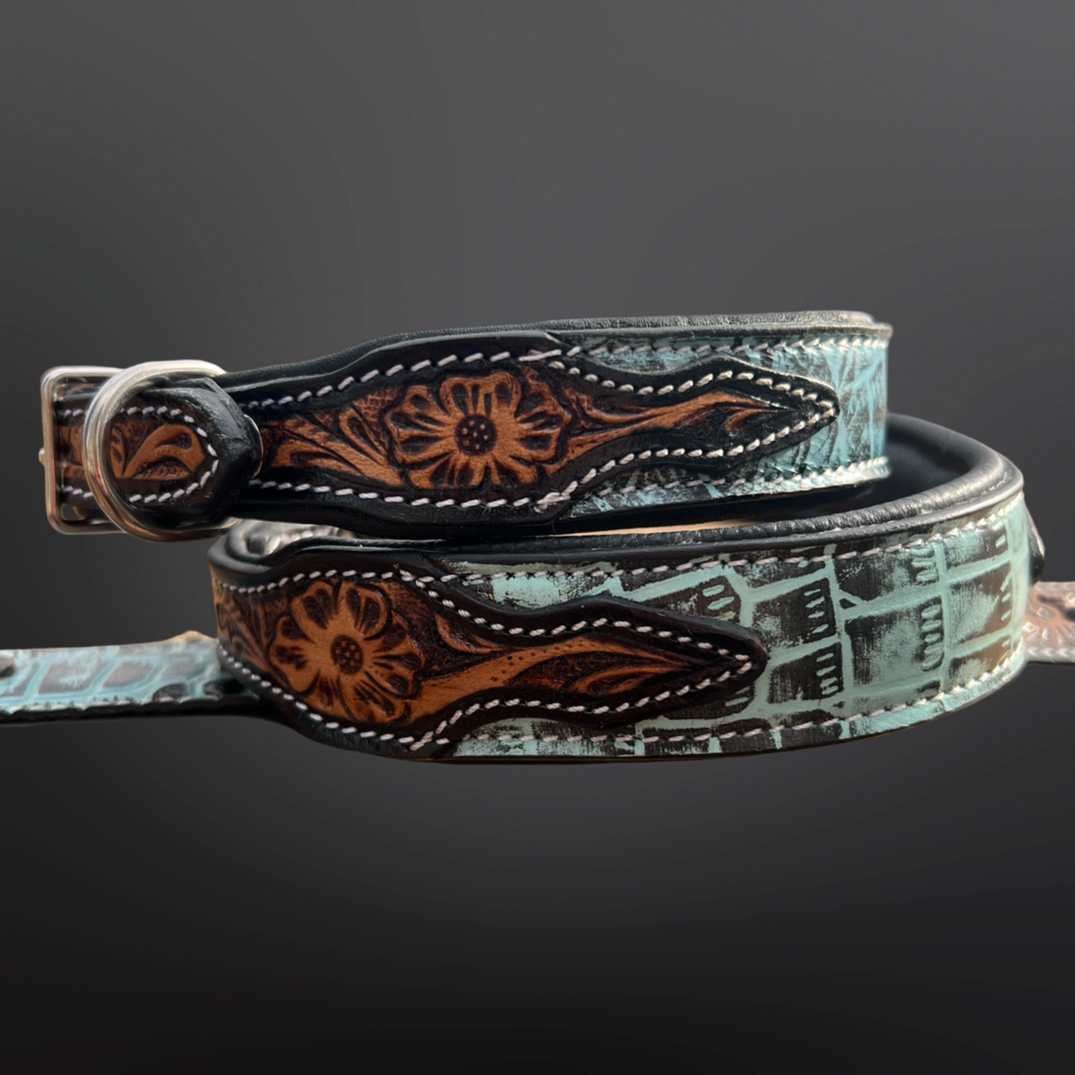 Western leather dog collar with intricate tooling and embossed turquoise leather on a dark background